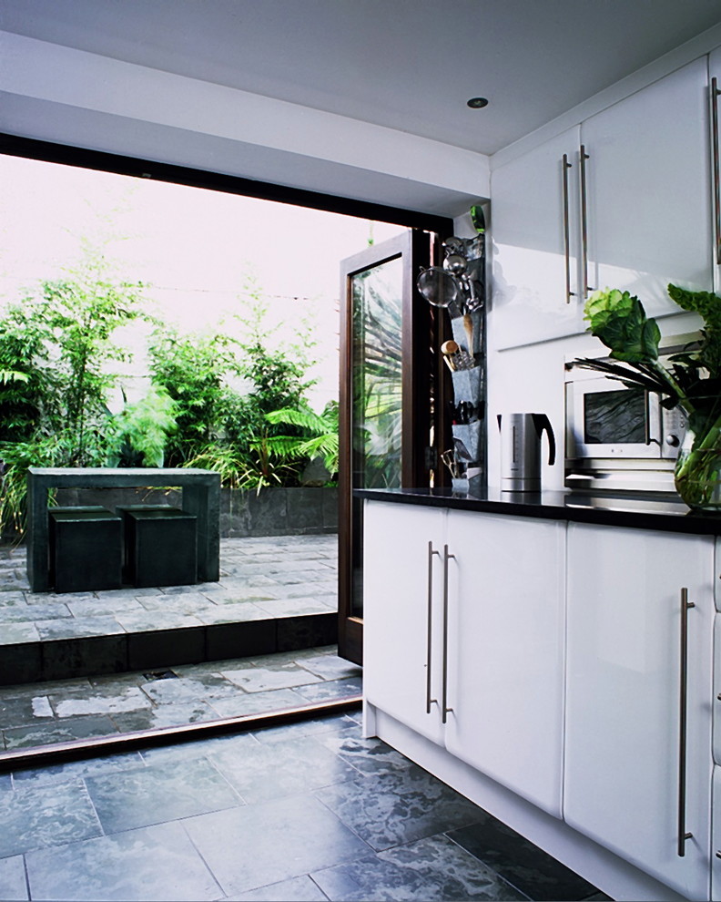 ロンドンにあるコンテンポラリースタイルのおしゃれなキッチン (フラットパネル扉のキャビネット、白いキャビネット) の写真