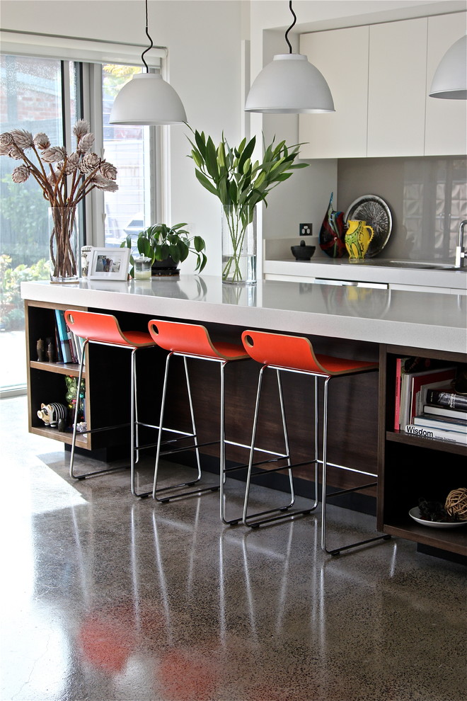 Esempio di una cucina design di medie dimensioni con lavello integrato, ante lisce, ante bianche, top in quarzo composito, paraspruzzi grigio, paraspruzzi con lastra di vetro e pavimento in cemento