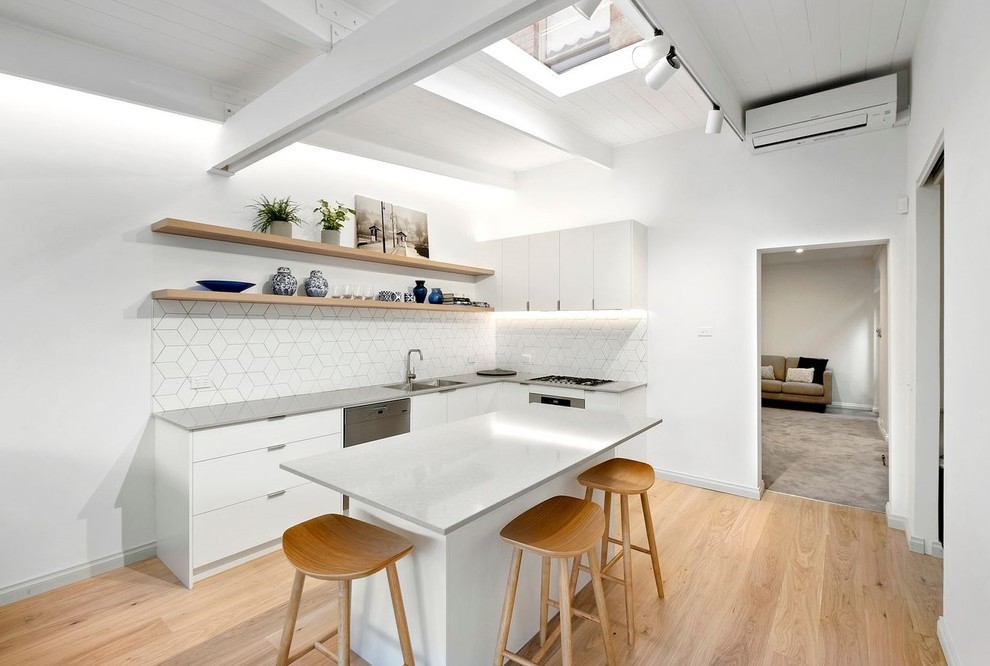 Esempio di una grande cucina contemporanea con lavello a doppia vasca, paraspruzzi bianco, paraspruzzi con piastrelle in ceramica, elettrodomestici in acciaio inossidabile, parquet chiaro, pavimento marrone e top grigio