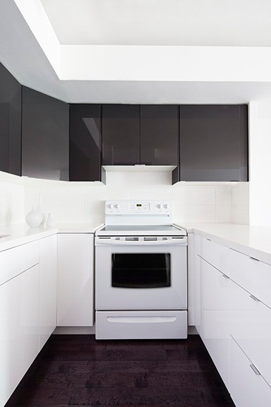 Inspiration för små moderna kök, med en undermonterad diskho, släta luckor, vitt stänkskydd, vita vitvaror, svarta skåp, bänkskiva i kvarts, mörkt trägolv och stänkskydd i keramik