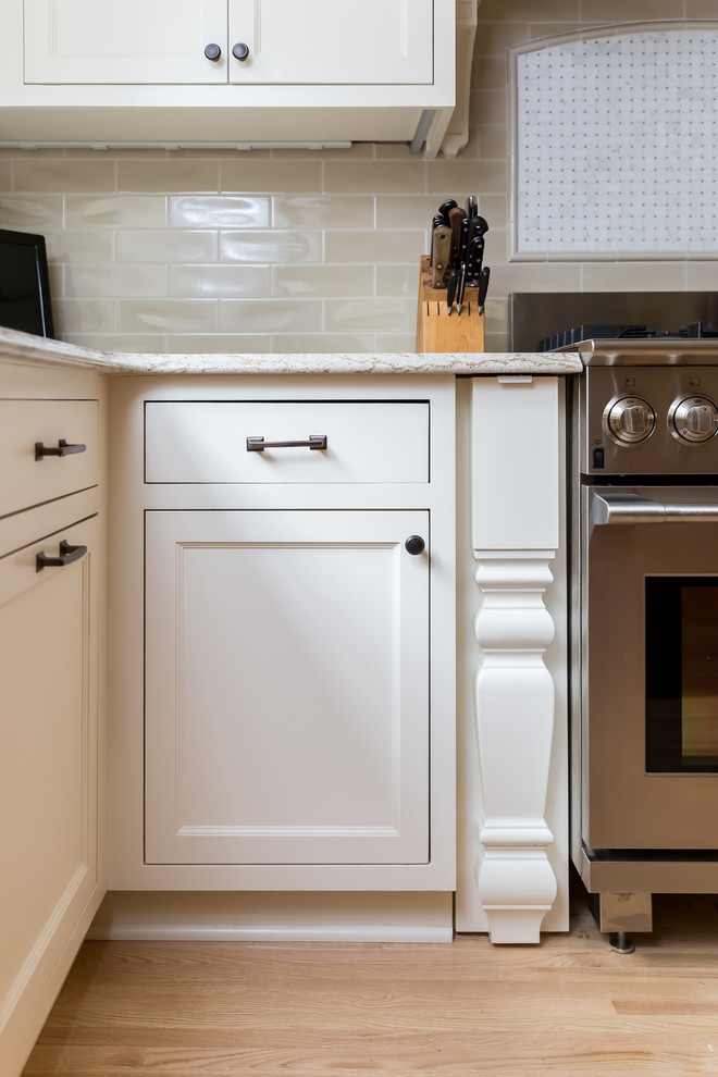 Idée de décoration pour une cuisine design avec des portes de placard blanches.