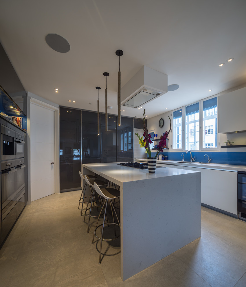Geschlossene Moderne Küche mit Unterbauwaschbecken, flächenbündigen Schrankfronten, schwarzen Elektrogeräten und Kücheninsel in London