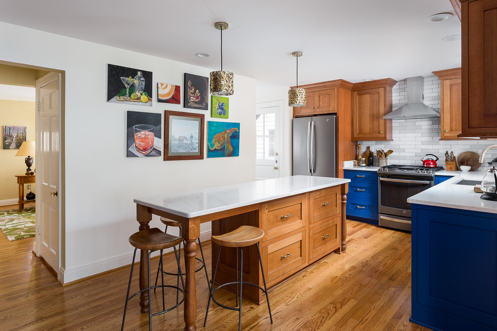 Inspiration for a small timeless l-shaped light wood floor and brown floor eat-in kitchen remodel in Louisville with an undermount sink, shaker cabinets, blue cabinets, quartz countertops, gray backsplash, subway tile backsplash, stainless steel appliances, two islands and white countertops