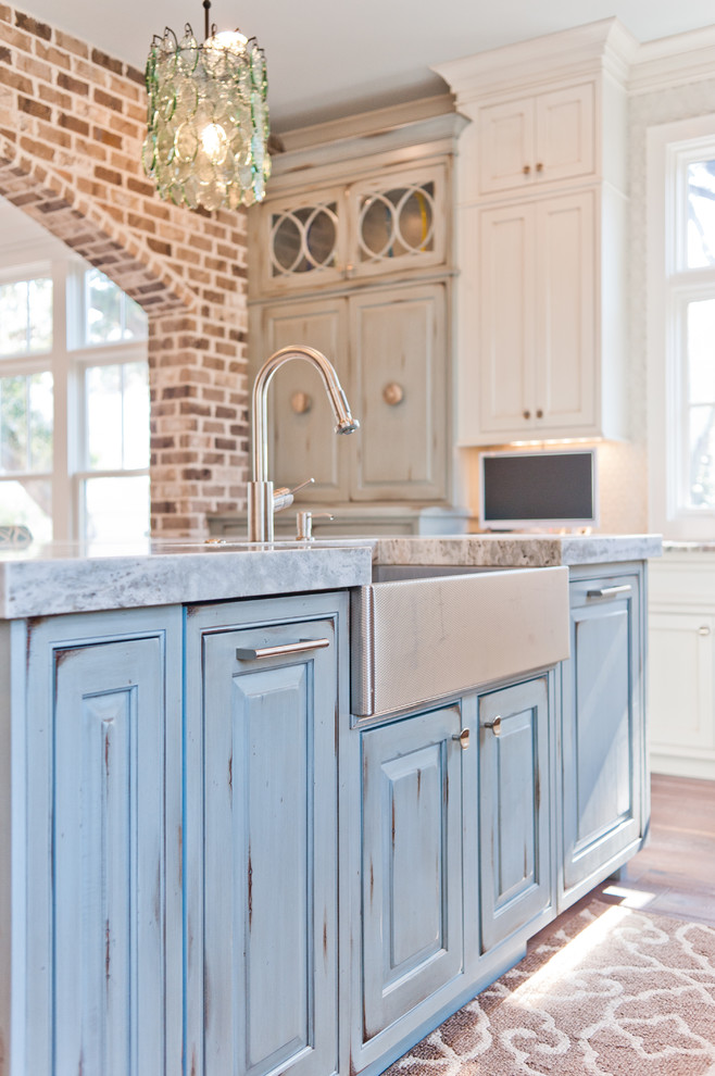 Large beach style u-shaped dark wood floor eat-in kitchen photo in Jacksonville with a farmhouse sink, beaded inset cabinets, white cabinets, marble countertops, white backsplash, glass sheet backsplash, paneled appliances and an island