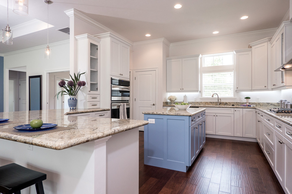 Inspiration for a contemporary dark wood floor kitchen remodel in Jacksonville with shaker cabinets, white cabinets, granite countertops, beige backsplash, cement tile backsplash, stainless steel appliances and two islands