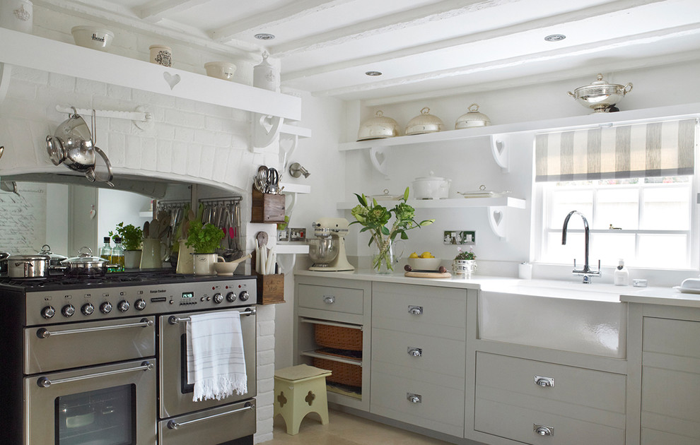 Cette image montre une cuisine style shabby chic avec un évier de ferme, une crédence blanche et un électroménager en acier inoxydable.