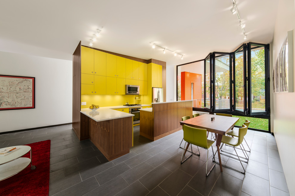 Idées déco pour une cuisine ouverte contemporaine en L avec un placard à porte plane, des portes de placard jaunes, une crédence jaune et un électroménager en acier inoxydable.