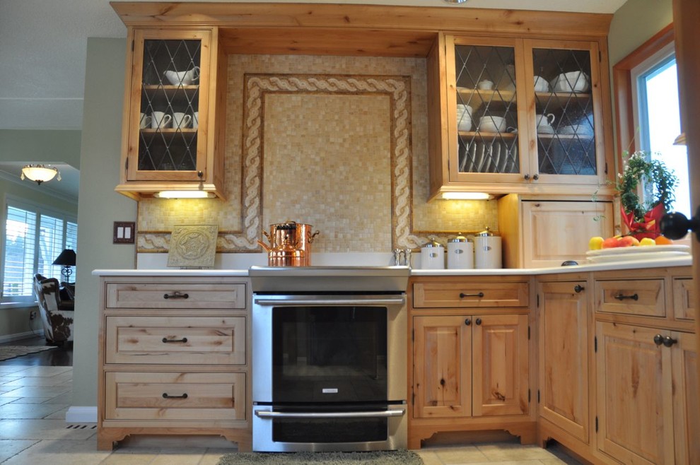 Immagine di una cucina abitabile stile rurale di medie dimensioni con ante con bugna sagomata, ante in legno chiaro, top in laminato, paraspruzzi beige, paraspruzzi in travertino, elettrodomestici in acciaio inossidabile, pavimento in travertino e pavimento beige