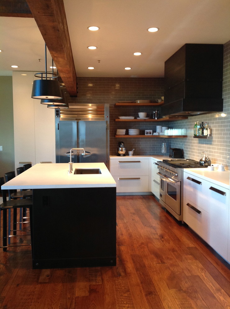 Exempel på ett industriellt kök, med en enkel diskho, släta luckor, vita skåp, marmorbänkskiva, grått stänkskydd, stänkskydd i keramik, rostfria vitvaror, mörkt trägolv och en köksö