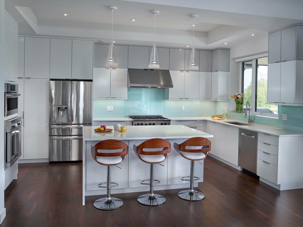 Example of a large trendy u-shaped dark wood floor enclosed kitchen design in Edmonton with a double-bowl sink, flat-panel cabinets, white cabinets, quartz countertops, blue backsplash, glass sheet backsplash, stainless steel appliances and an island