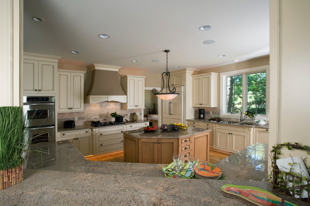 Mid-sized elegant u-shaped medium tone wood floor eat-in kitchen photo in Chicago with a double-bowl sink, recessed-panel cabinets, white cabinets, granite countertops, beige backsplash, stone tile backsplash, paneled appliances and two islands