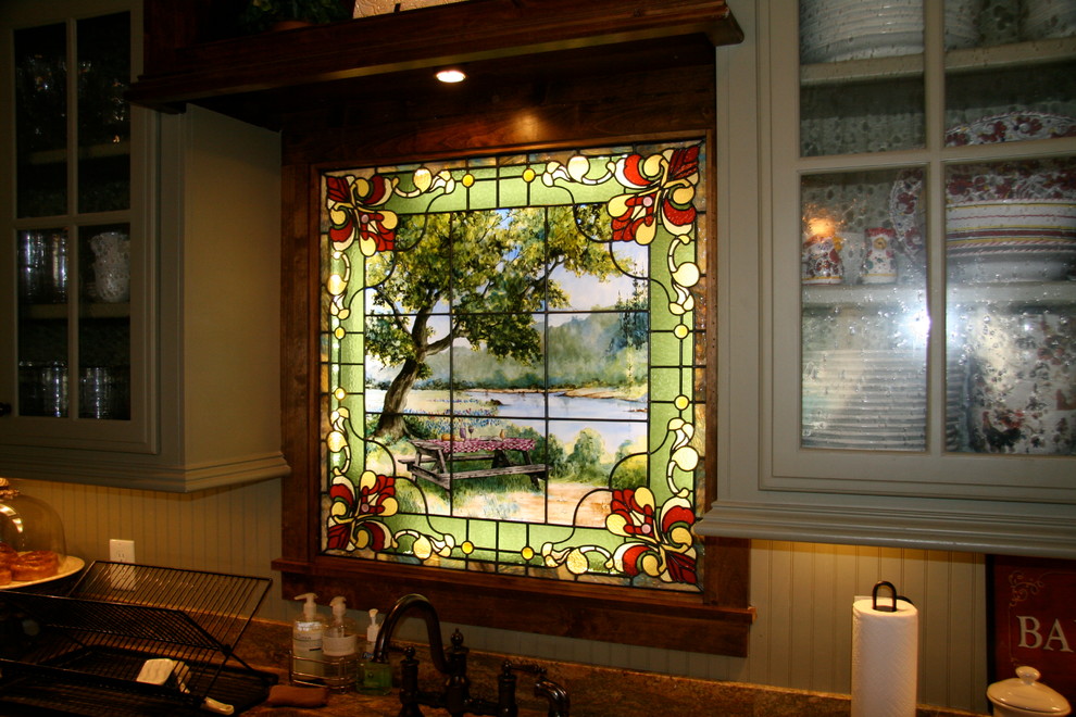 Imagen de cocina clásica de tamaño medio con armarios tipo vitrina, puertas de armario verdes, encimera de granito, salpicadero beige y una isla