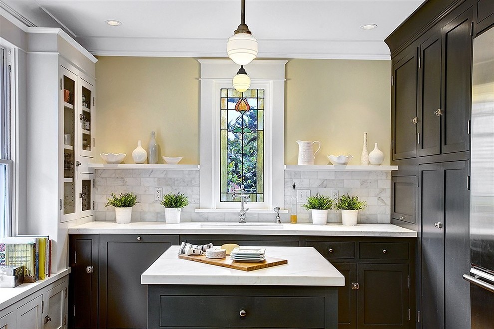 Inspiration för mellanstora amerikanska vitt kök, med en undermonterad diskho, skåp i shakerstil, svarta skåp, marmorbänkskiva, grått stänkskydd, stänkskydd i marmor, rostfria vitvaror, ljust trägolv, en köksö och beiget golv