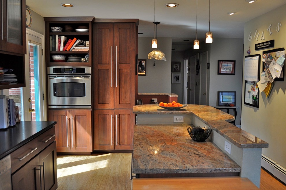 Exempel på ett avskilt, stort klassiskt l-kök, med en dubbel diskho, skåp i shakerstil, skåp i mörkt trä, granitbänkskiva, stänkskydd med metallisk yta, stänkskydd i metallkakel, rostfria vitvaror, ljust trägolv, en köksö och brunt golv