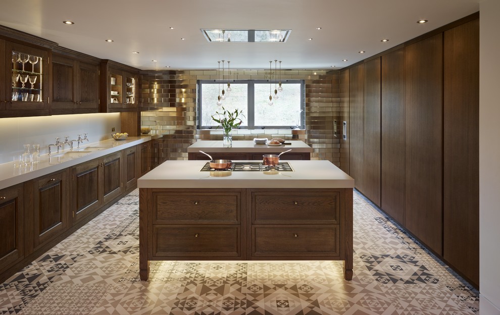 This is an example of a medium sized bohemian galley enclosed kitchen in Kent with a submerged sink, raised-panel cabinets, dark wood cabinets, quartz worktops, grey splashback, black appliances, porcelain flooring and multiple islands.