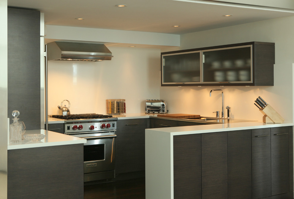 Mittelgroße Moderne Küche mit flächenbündigen Schrankfronten, dunklen Holzschränken und weißer Arbeitsplatte in New York
