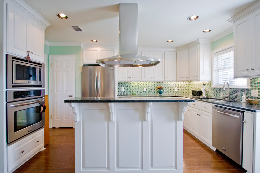Inspiration for a classic u-shaped kitchen in Little Rock with a submerged sink, raised-panel cabinets, white cabinets, green splashback, mosaic tiled splashback and stainless steel appliances.