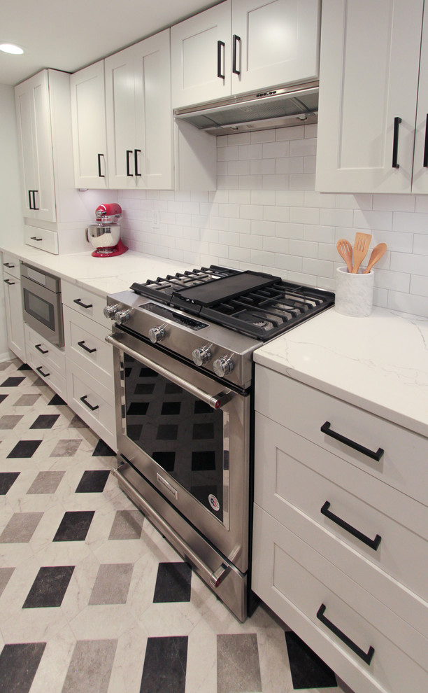 Exempel på ett stort modernt vit vitt kök, med en undermonterad diskho, luckor med infälld panel, vita skåp, marmorbänkskiva, vitt stänkskydd, stänkskydd i tunnelbanekakel, rostfria vitvaror, klinkergolv i keramik, en halv köksö och flerfärgat golv