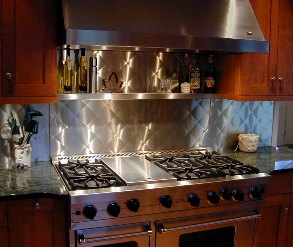 Diseño de cocina comedor lineal clásica con salpicadero metalizado, salpicadero de metal y electrodomésticos de acero inoxidable