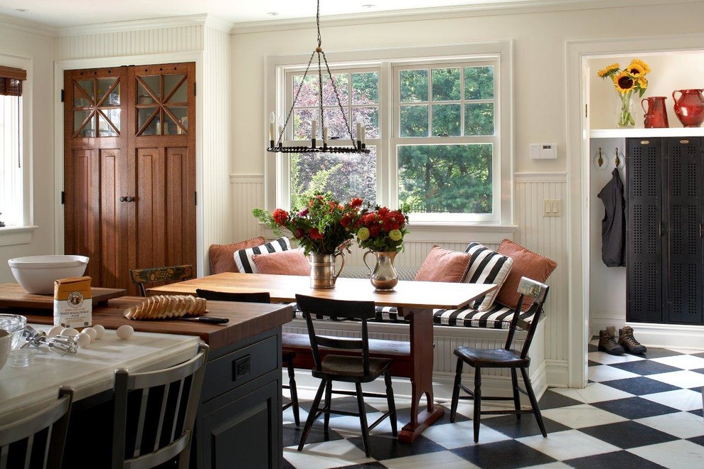 Lantlig inredning av ett mellanstort linjärt kök och matrum, med en undermonterad diskho, luckor med upphöjd panel, vita skåp, granitbänkskiva, vitt stänkskydd, stänkskydd i trä, rostfria vitvaror, klinkergolv i keramik, en köksö och flerfärgat golv