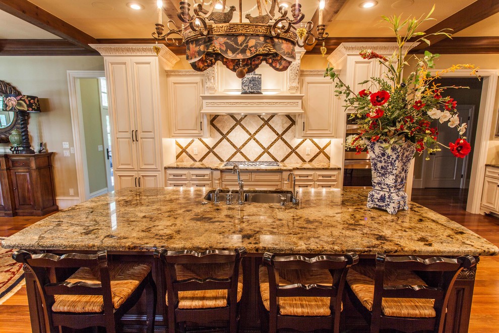 Inspiration for a huge transitional u-shaped medium tone wood floor eat-in kitchen remodel in Other with an undermount sink, raised-panel cabinets, white cabinets, granite countertops, metallic backsplash, stone tile backsplash, stainless steel appliances and an island