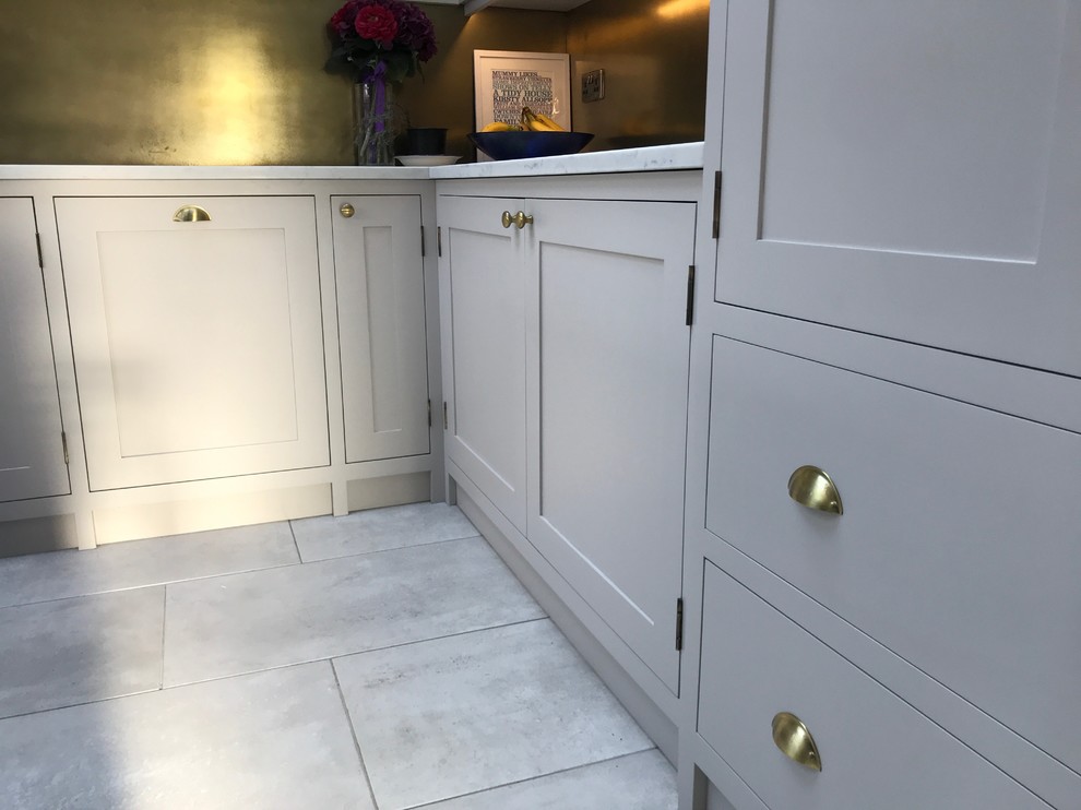 Example of a mid-sized classic l-shaped ceramic tile and gray floor eat-in kitchen design in Manchester with a drop-in sink, shaker cabinets, blue cabinets, quartzite countertops, metallic backsplash, paneled appliances, an island and white countertops