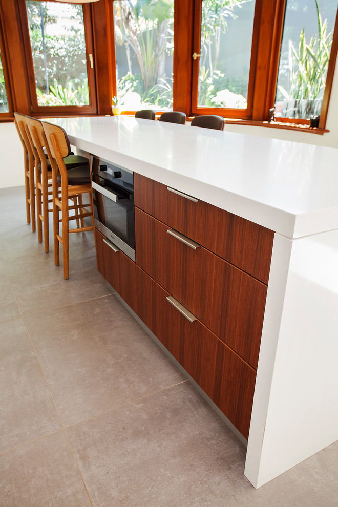 Inspiration for a large contemporary l-shaped concrete floor open concept kitchen remodel in Sydney with an undermount sink, flat-panel cabinets, white cabinets, quartz countertops, gray backsplash, mirror backsplash, black appliances and an island