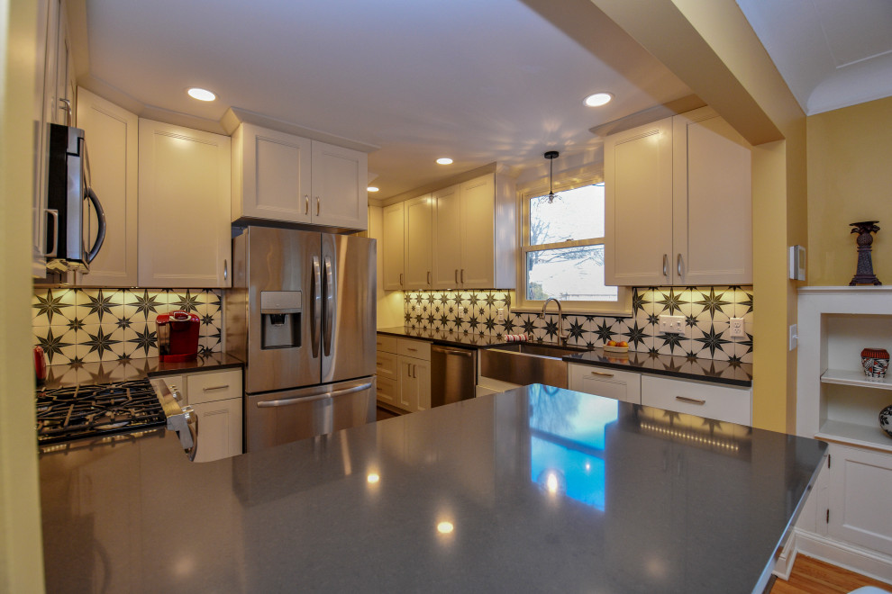 Example of a mid-sized arts and crafts galley vinyl floor and gray floor eat-in kitchen design in Minneapolis with a farmhouse sink, recessed-panel cabinets, white cabinets, granite countertops, multicolored backsplash, porcelain backsplash, stainless steel appliances, a peninsula and gray countertops