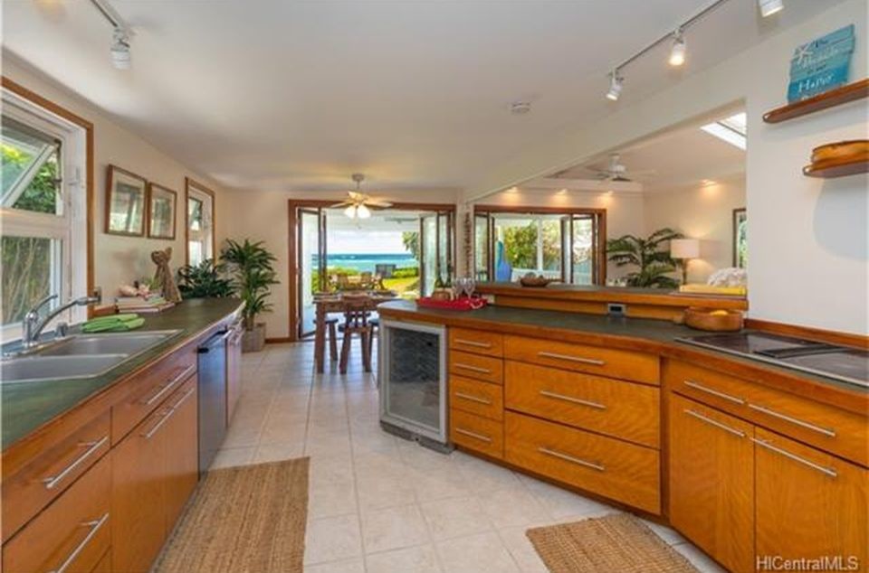 Example of a mid-sized trendy porcelain tile and beige floor kitchen design in Hawaii with a drop-in sink, flat-panel cabinets, medium tone wood cabinets, concrete countertops, stainless steel appliances and no island