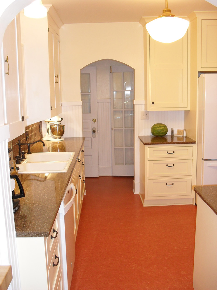 Foto på ett avskilt, mellanstort vintage kök, med gula skåp, vita vitvaror, en nedsänkt diskho, luckor med infälld panel, stänkskydd med metallisk yta och stänkskydd i metallkakel