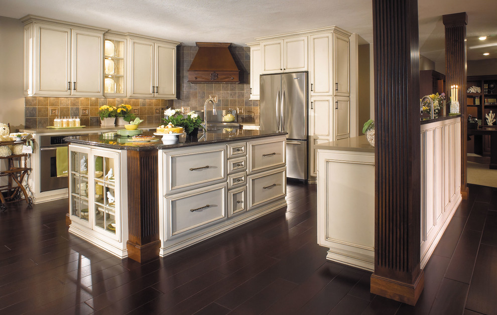 Exempel på ett avskilt, stort klassiskt l-kök, med en undermonterad diskho, luckor med infälld panel, vita skåp, granitbänkskiva, flerfärgad stänkskydd, stänkskydd i skiffer, rostfria vitvaror, mörkt trägolv, flera köksöar och brunt golv