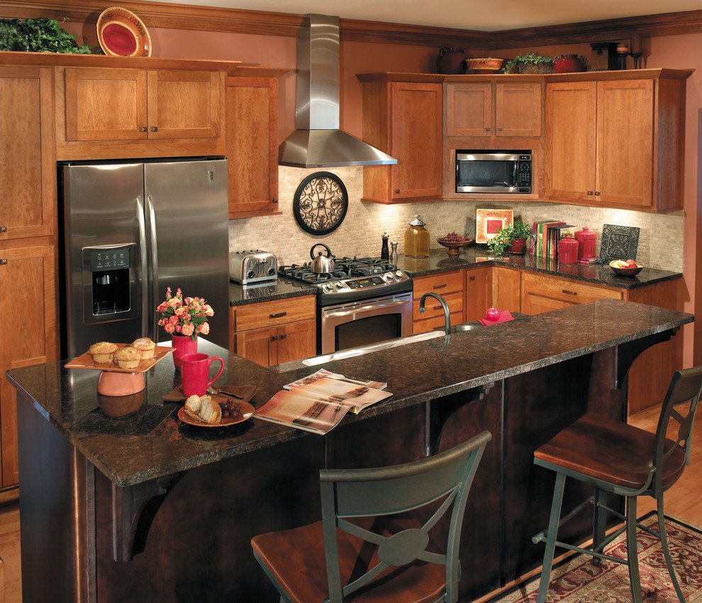Idéer för mellanstora vintage kök, med skåp i mellenmörkt trä, grått stänkskydd, rostfria vitvaror, mellanmörkt trägolv, en köksö, en nedsänkt diskho, luckor med infälld panel, granitbänkskiva och brunt golv