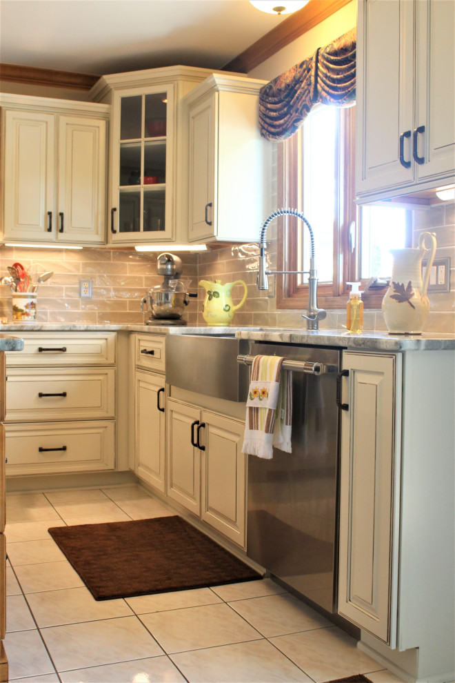 Foto di una grande cucina tradizionale con lavello sottopiano, ante con bugna sagomata, ante beige, top in quarzite, paraspruzzi beige, paraspruzzi con piastrelle in ceramica, elettrodomestici in acciaio inossidabile, pavimento con piastrelle in ceramica, pavimento beige e top beige