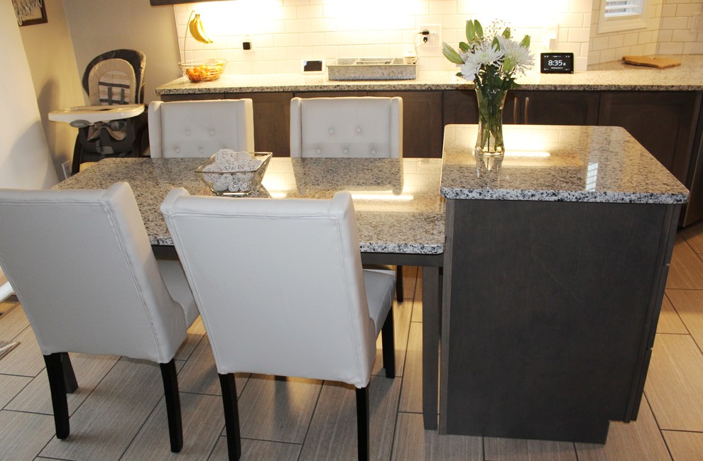 Exempel på ett avskilt, mellanstort klassiskt grå grått l-kök, med en enkel diskho, skåp i shakerstil, grå skåp, granitbänkskiva, vitt stänkskydd, stänkskydd i keramik, rostfria vitvaror, klinkergolv i porslin, en köksö och grått golv