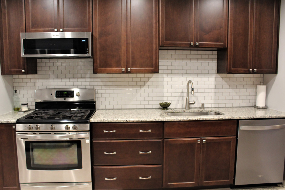 Imagen de cocina comedor contemporánea con armarios con paneles empotrados, puertas de armario de madera en tonos medios, encimera de granito y encimeras marrones