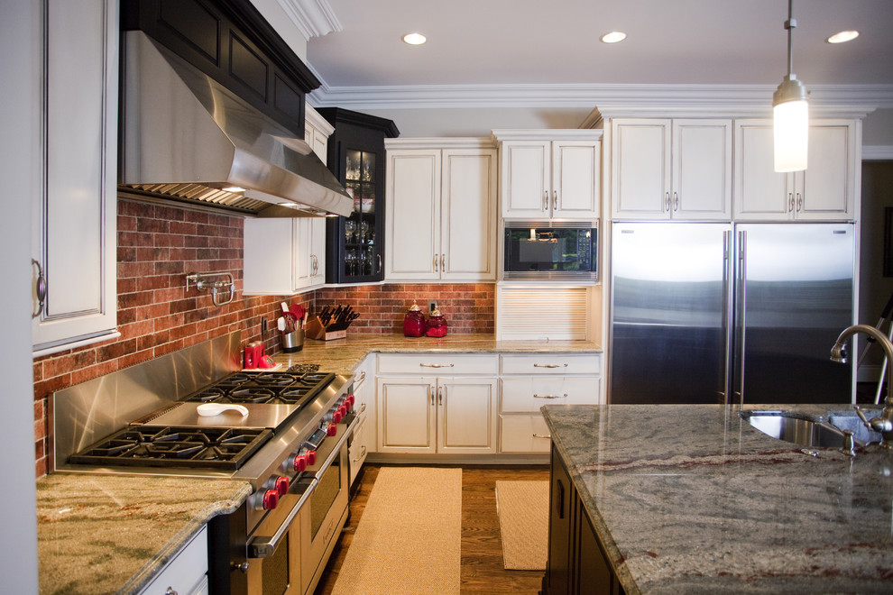 Eklektisk inredning av ett kök, med en undermonterad diskho, luckor med upphöjd panel, vita skåp, granitbänkskiva, flerfärgad stänkskydd, stänkskydd i stenkakel och rostfria vitvaror