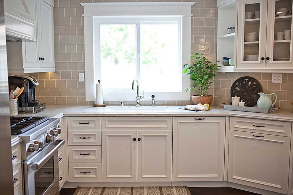 Inspiration for a small timeless u-shaped dark wood floor open concept kitchen remodel in San Diego with an undermount sink, beaded inset cabinets, white cabinets, quartzite countertops, beige backsplash, ceramic backsplash, stainless steel appliances and an island