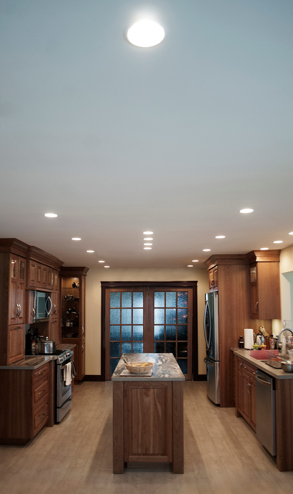 Foto di una grande cucina design con lavello da incasso, ante in legno scuro, top in granito, elettrodomestici in acciaio inossidabile e pavimento in legno massello medio