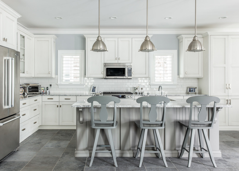 Inspiration for a large timeless l-shaped slate floor kitchen remodel in New York with white cabinets, granite countertops, white backsplash, subway tile backsplash, an island, stainless steel appliances and recessed-panel cabinets