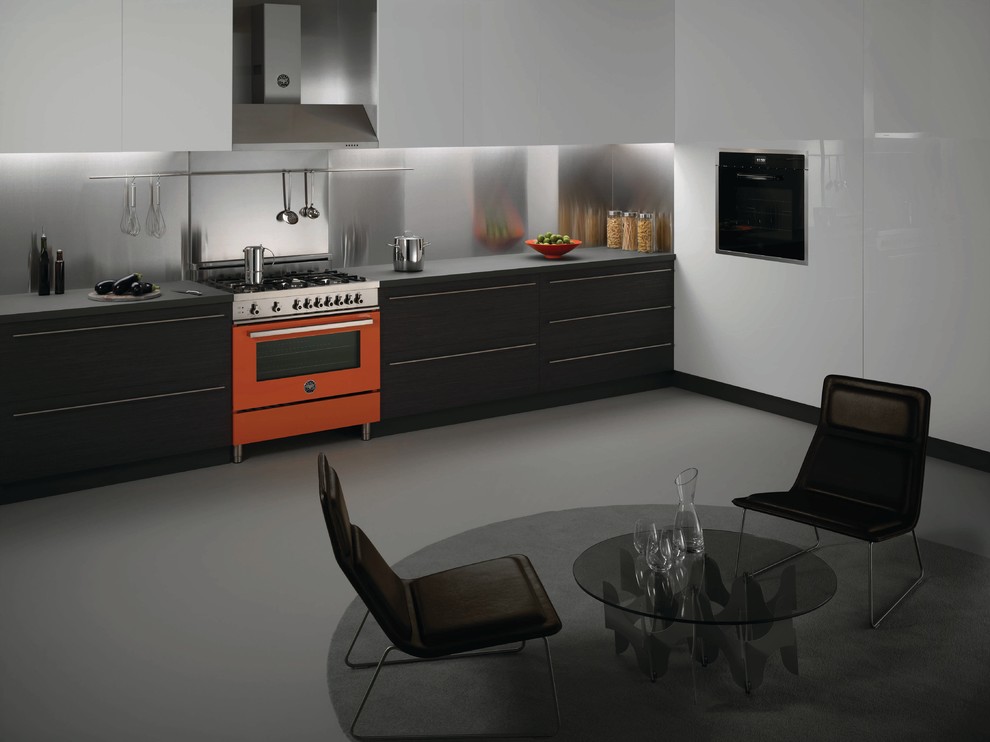Modern inredning av ett avskilt, stort linjärt kök, med släta luckor, svarta skåp, bänkskiva i koppar, stänkskydd med metallisk yta, stänkskydd i metallkakel och färgglada vitvaror