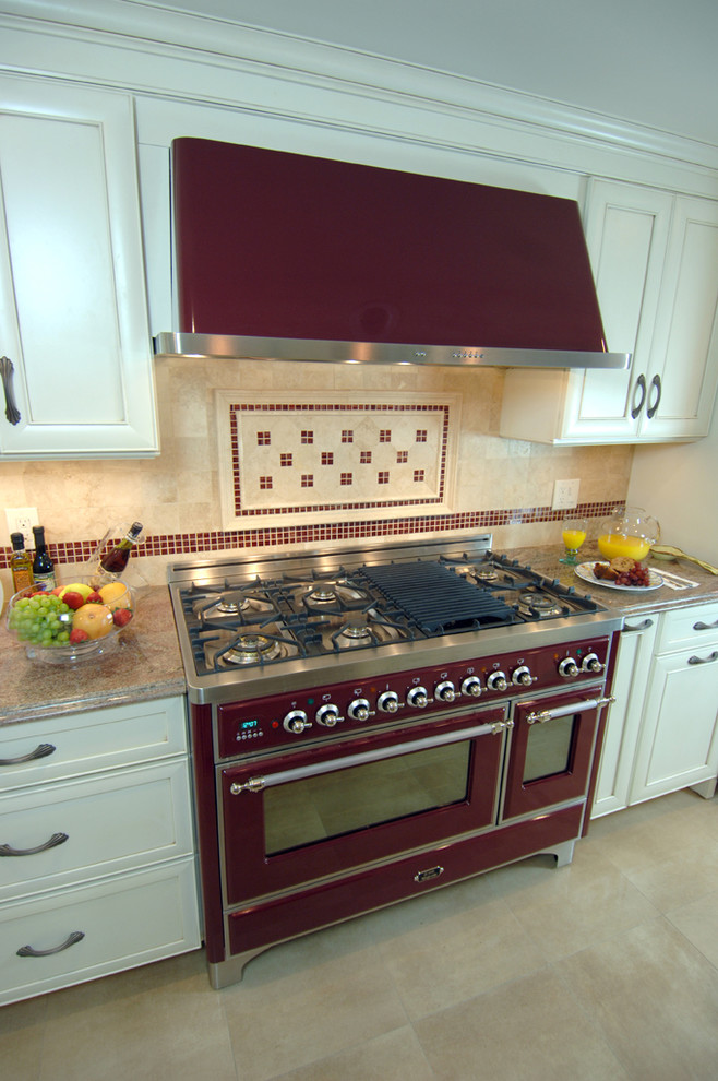 Example of a mid-sized classic limestone floor kitchen design in New York with shaker cabinets, white cabinets, granite countertops, multicolored backsplash, stone tile backsplash and colored appliances