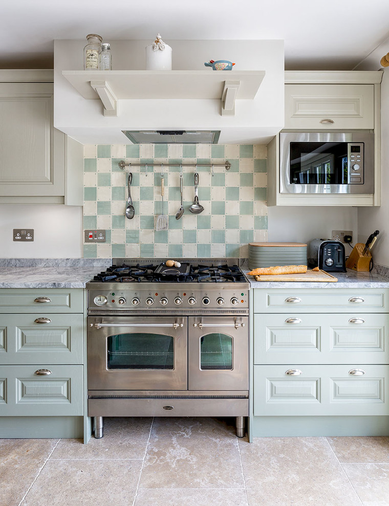 Klassisk inredning av ett stort kök, med en rustik diskho, skåp i shakerstil, skåp i ljust trä, marmorbänkskiva, grönt stänkskydd, stänkskydd i keramik, integrerade vitvaror, kalkstensgolv och en halv köksö
