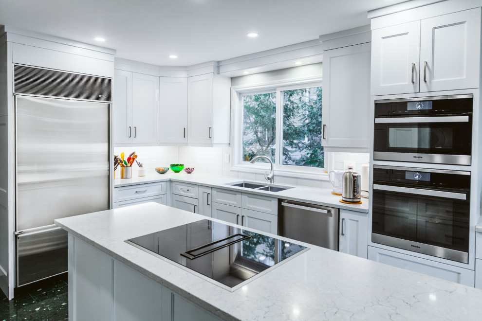 Inspiration for a medium sized traditional l-shaped enclosed kitchen in Toronto with a submerged sink, shaker cabinets, white cabinets, engineered stone countertops, blue splashback, glass tiled splashback, stainless steel appliances, ceramic flooring, an island, green floors and grey worktops.