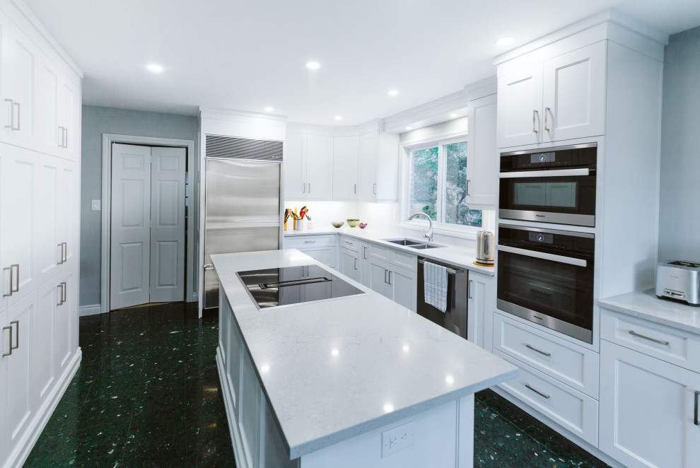 Medium sized classic l-shaped enclosed kitchen in Toronto with a submerged sink, shaker cabinets, white cabinets, engineered stone countertops, blue splashback, glass tiled splashback, stainless steel appliances, ceramic flooring, an island, green floors and grey worktops.