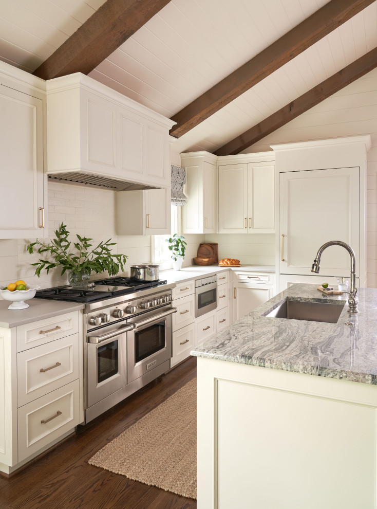 Immagine di un cucina con isola centrale country con top in granito, elettrodomestici in acciaio inossidabile, top grigio e travi a vista