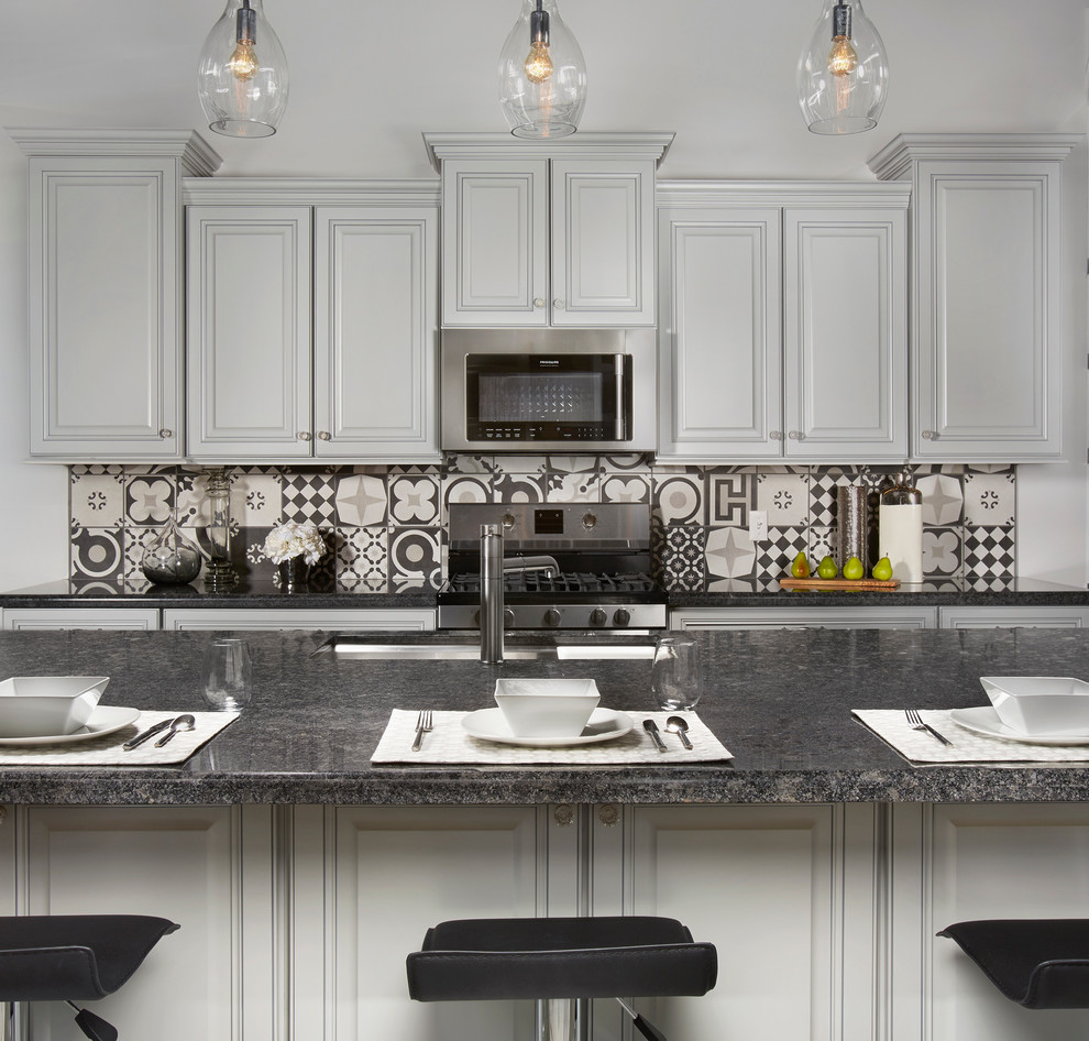 Exempel på ett mellanstort modernt linjärt kök och matrum, med en nedsänkt diskho, luckor med upphöjd panel, grå skåp, granitbänkskiva, svart stänkskydd, stänkskydd i porslinskakel, rostfria vitvaror och en köksö