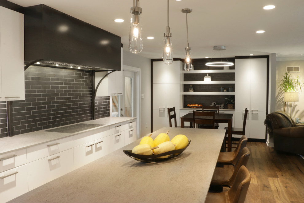 Design ideas for a medium sized industrial galley kitchen/diner in Other with white cabinets, grey splashback, metro tiled splashback, stainless steel appliances, light hardwood flooring, an island and beige floors.