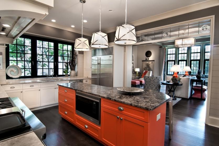 Example of a mid-sized eclectic u-shaped black floor open concept kitchen design in Charleston with an undermount sink, glass-front cabinets, white cabinets, soapstone countertops, white backsplash, wood backsplash, stainless steel appliances and an island