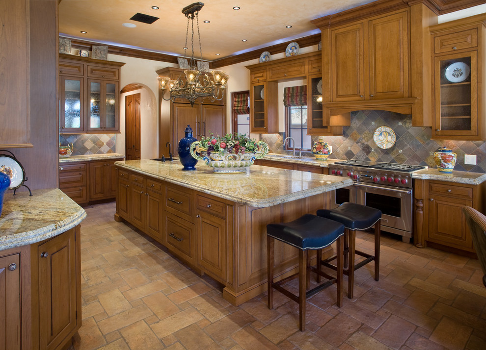 Photo of a large mediterranean grey and cream u-shaped open plan kitchen in Orlando with raised-panel cabinets, medium wood cabinets, multi-coloured splashback, stainless steel appliances, granite worktops, ceramic flooring, an island and slate splashback.