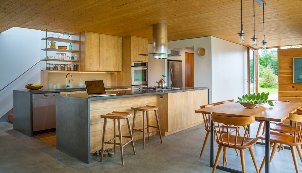 Idéer för ett modernt kök och matrum, med släta luckor, skåp i mellenmörkt trä, rostfria vitvaror, betonggolv, en köksö och bänkskiva i betong